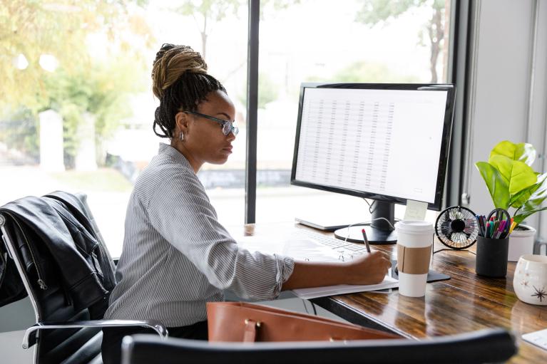 A mid adult African American businesswoman concentrates while working in her office.